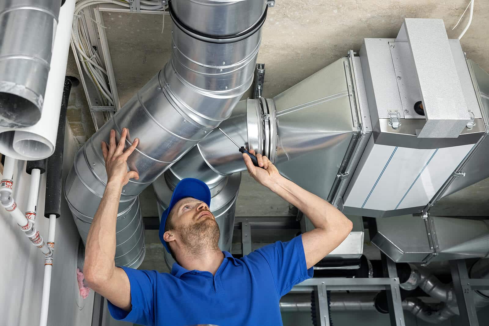 HVAC technician inspecting and repairing air ducts in Pleasanton