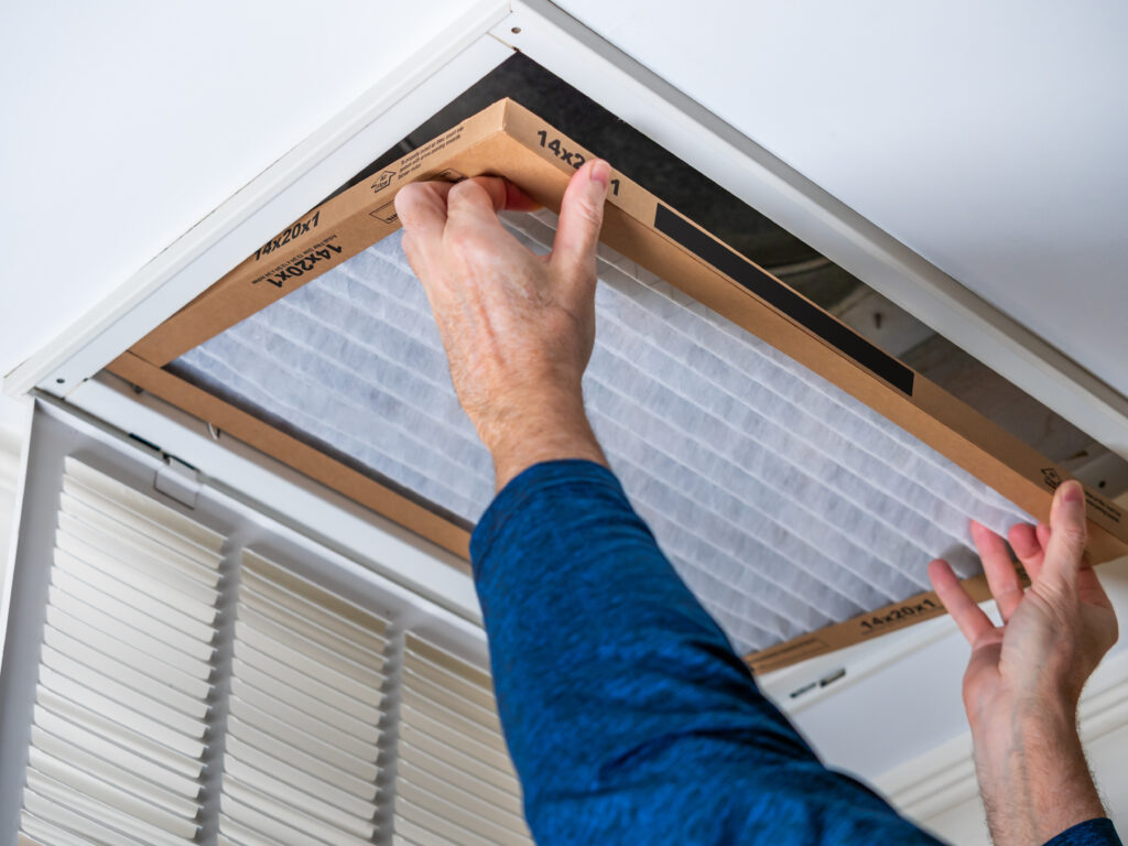 HVAC technician replacing a home air filter in Pleasanton